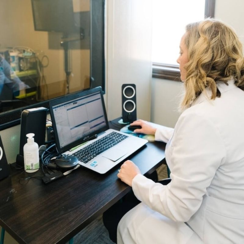 A photo of an audiologist conducting a hearing test